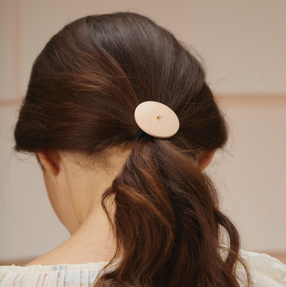 Mannequin portant un élastique rose pour cheveux Rosematic